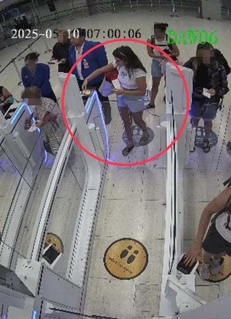Security camera footage of a woman at an airport checkpoint.