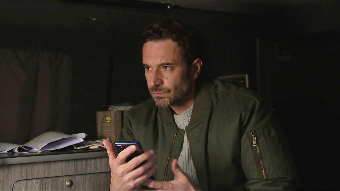 A man looking concerned while looking at his phone.