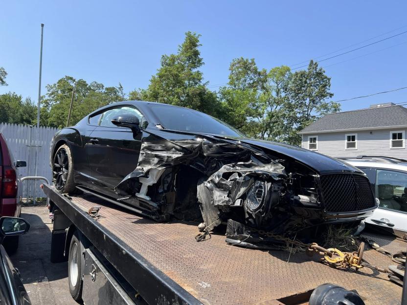 Damaged black car on a tow truck.