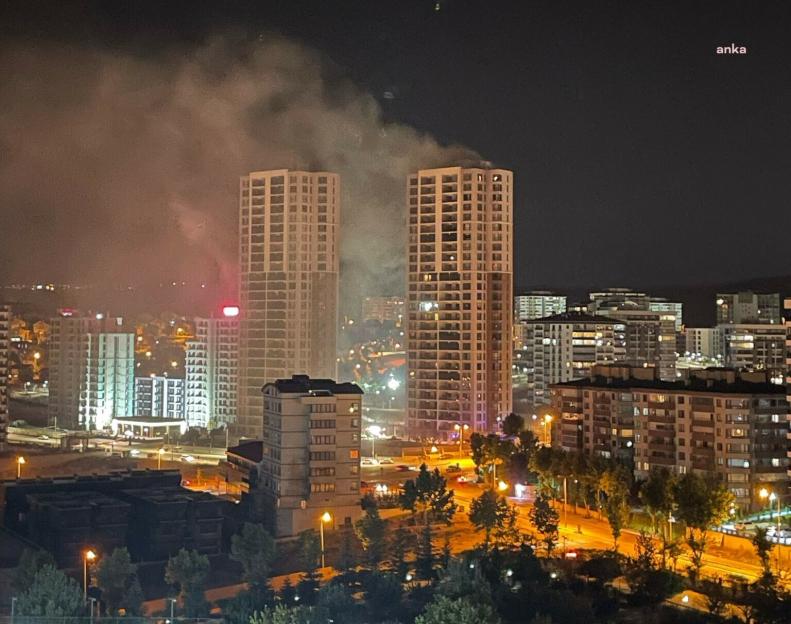Nighttime view of a city with smoke rising from a building fire.