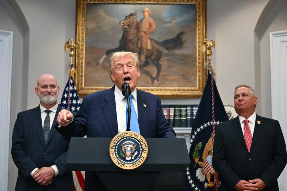 President Trump speaking at a podium with two other men.