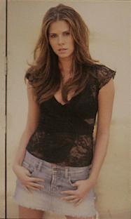 Woman in black lace top and denim skirt.