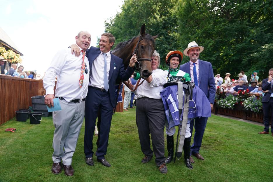 Winning horse, jockey, and trainers at a race.