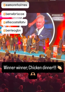 Screenshot of an awards ceremony with winners on stage and audience; social media handles are tagged.