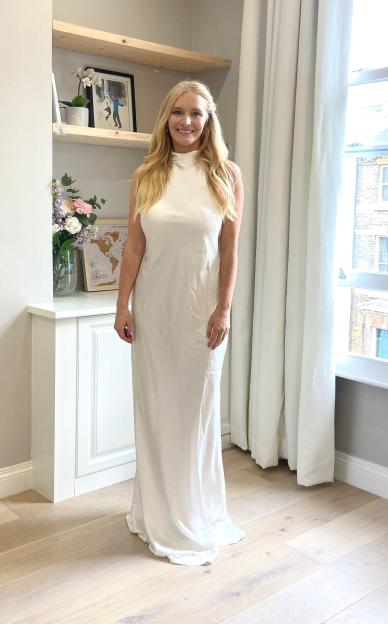 Woman in a long white dress in a living room.