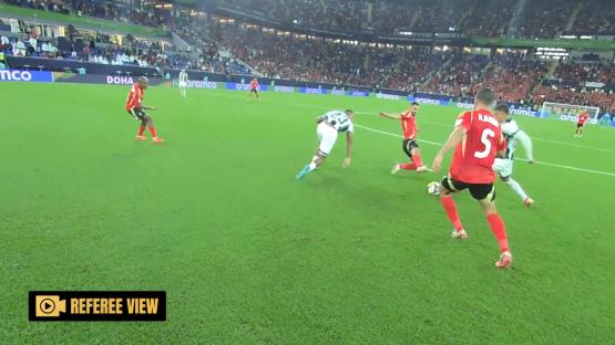 Referee view of soccer players on a field.