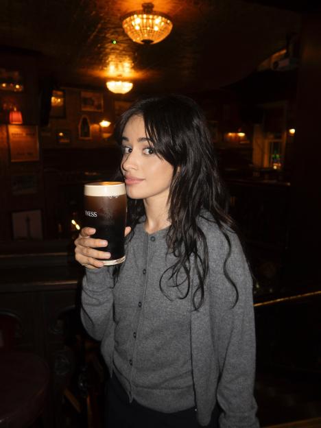 Camila Cabello holding a pint of Guinness.