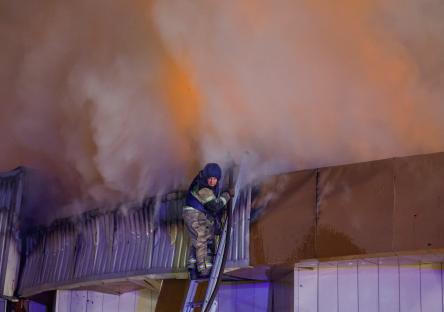 Firefighter battling a fire at a market.
