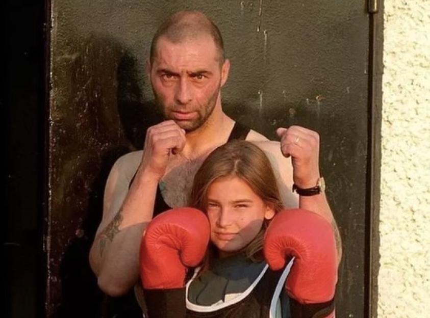 A man and a young girl wearing boxing gloves.