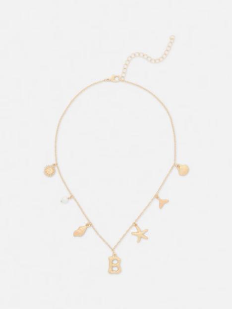 Gold initial charm necklace with beach-inspired charms.
