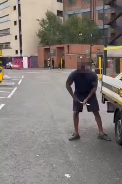 A man slashing a truck's tires with a knife.