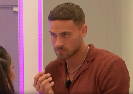 Screenshot of a man speaking to a woman.