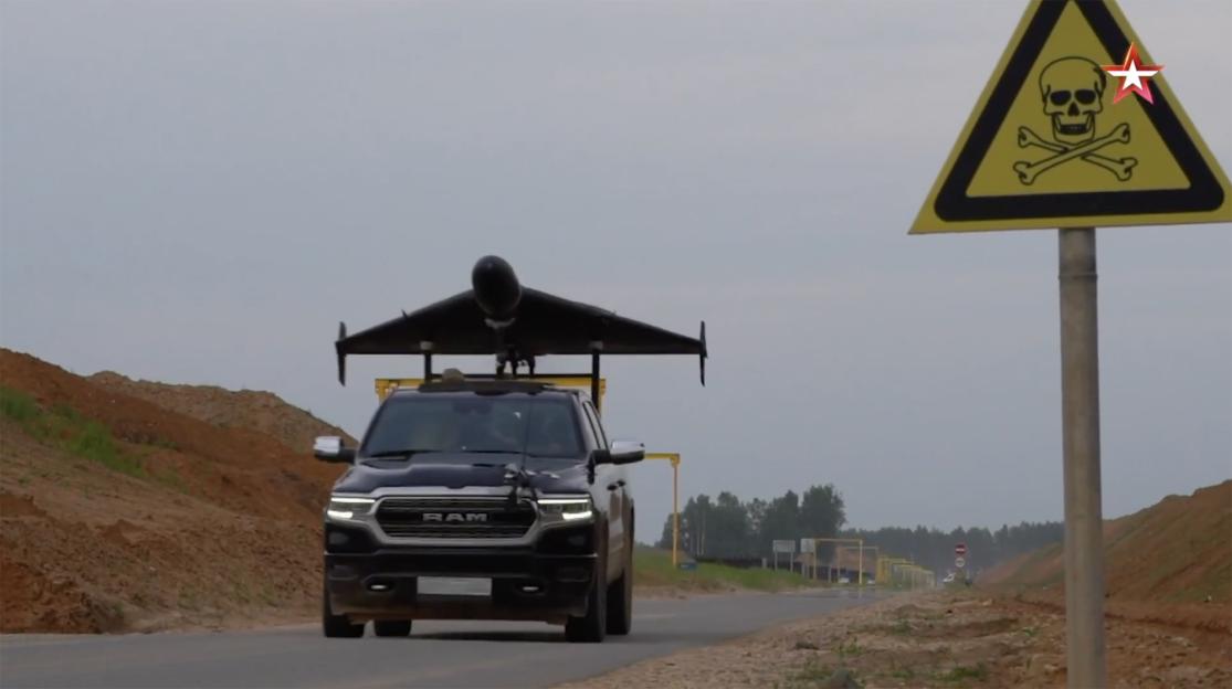 A pickup truck carrying a Geran-2 drone, with a skull and crossbones sign in the background.