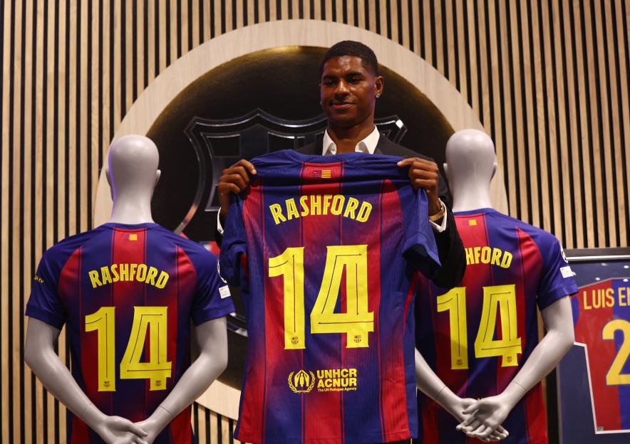 Marcus Rashford holding his new FC Barcelona jersey.