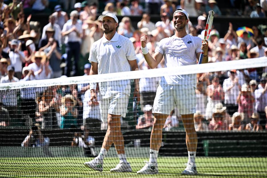 Two male tennis players celebrating a win at Wimbledon.