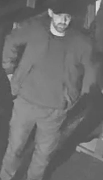 Surveillance image of a man in a hoodie and pants.