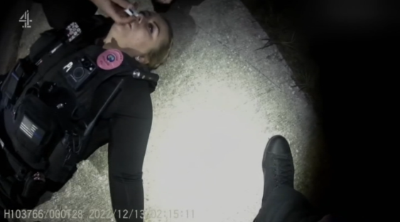 Police officer lying on the ground.
