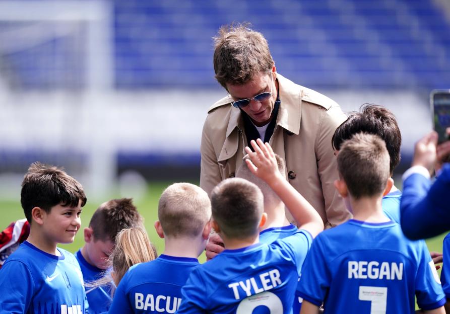Tom Brady signing autographs for young soccer fans.