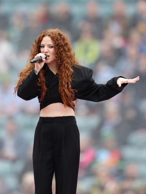Jess Glynne performing at a rugby match.