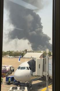 Large plume of smoke at an airport.