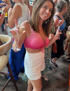 Woman holding a glass of champagne at a party.