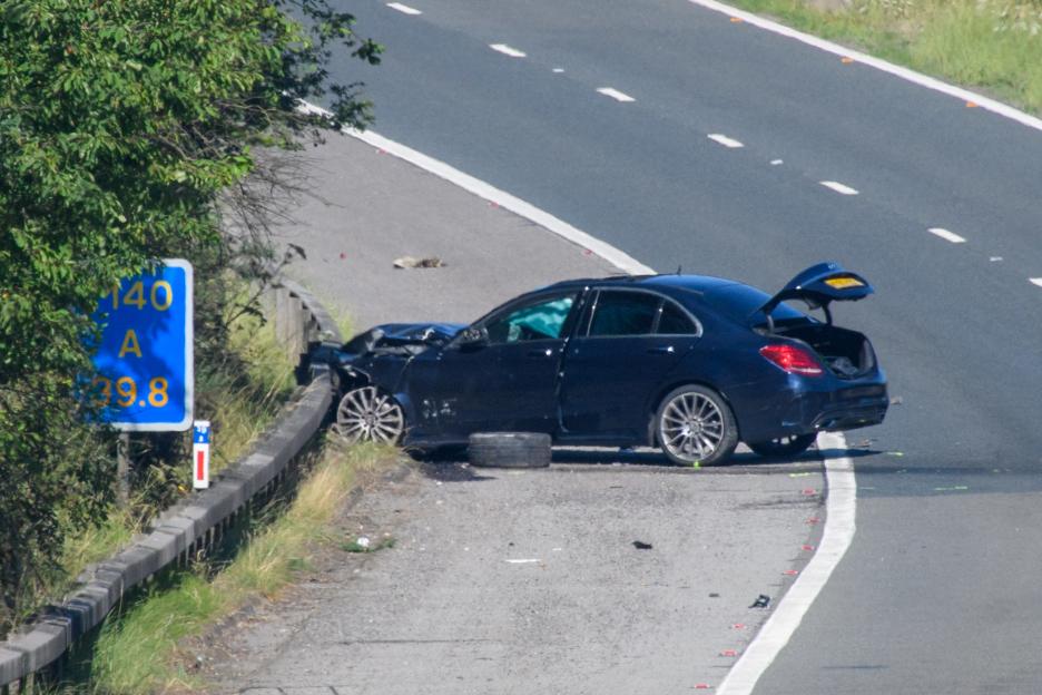 Damaged Mercedes-Benz C250 at the scene of a fatal car accident on a highway.