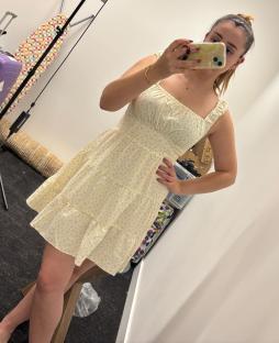 Woman modeling a pale yellow floral dress.