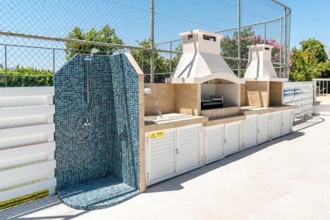 Outdoor shower and built-in barbecue with storage.