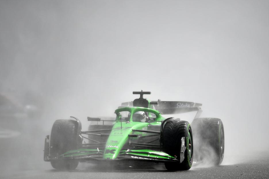Nico Hulkenberg driving a green Formula 1 car in the rain.