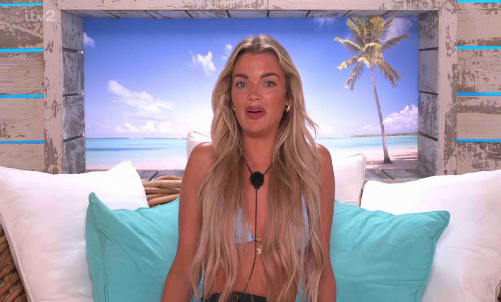 Helena from Love Island sits on a daybed and speaks.