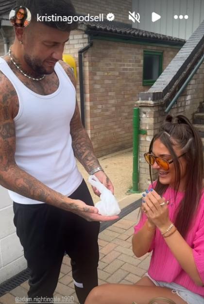 A man giving a woman a small gift in a plastic bag.