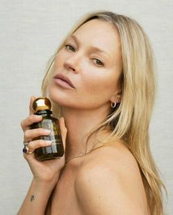 Kate Moss holding Cosmoss Sacred Mist perfume.