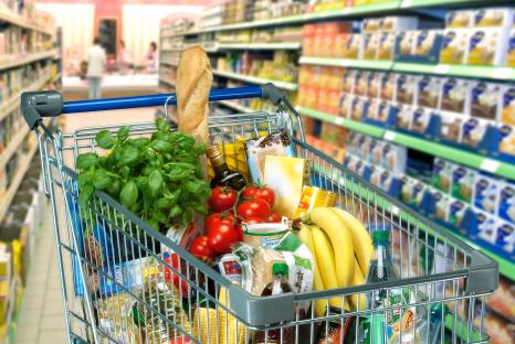 Shopping cart full of groceries in a supermarket.