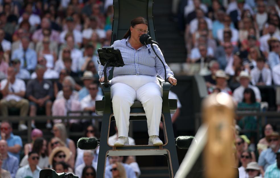 Chair umpire Alison Hughes MBE speaking into a microphone at Wimbledon.
