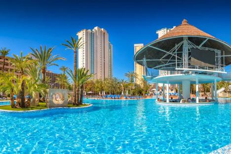 Large pool with swim-up bar and palm trees.