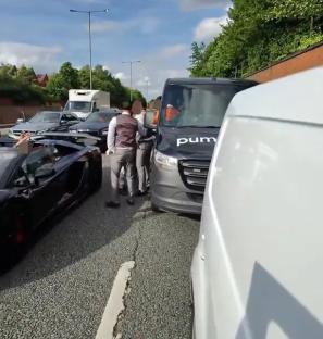 A road rage incident on a busy road in London, involving several cars and a van.