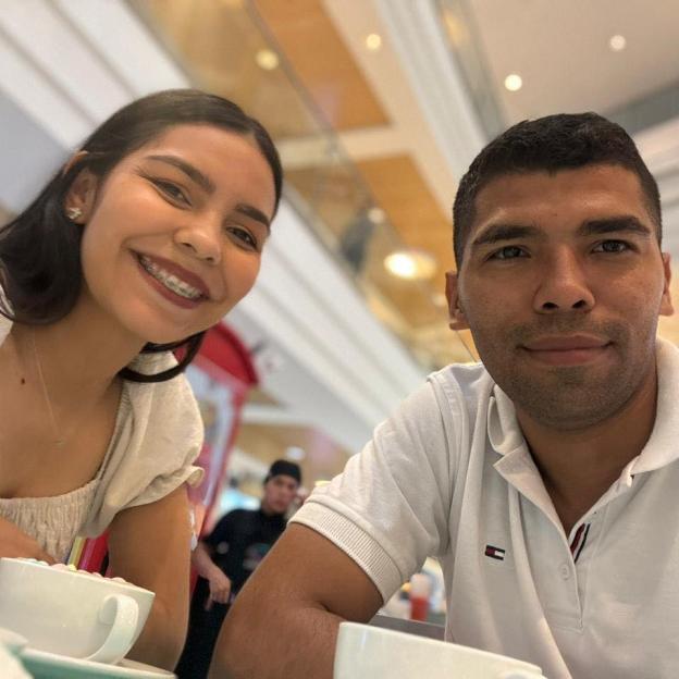 Photo of a young couple smiling at the camera.