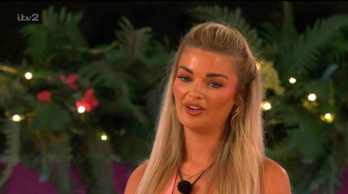 A blonde woman speaks on Love Island.