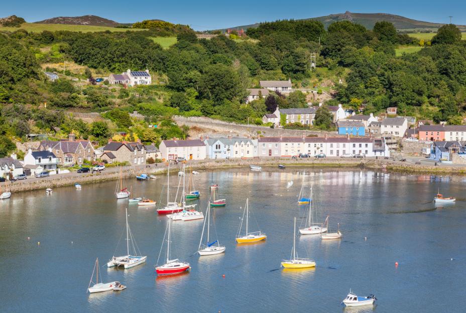 Harbor at Lower Town, Fishguard, Wales with colorful houses and sailboats.