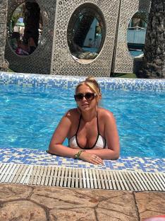 Woman in a white bikini relaxing in a pool.