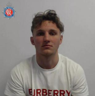 Mugshot of a young man wearing a white t-shirt.