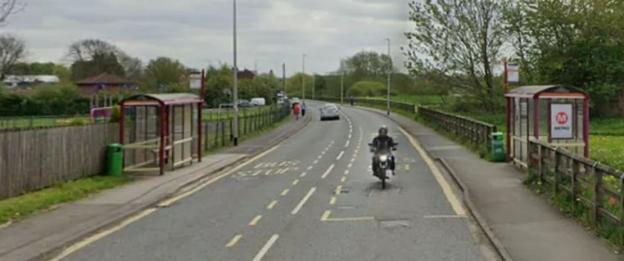 Motorcyclist on Leeds Rd. near bus stops.