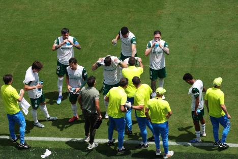 Palmeiras soccer players take a drinks break on the field.