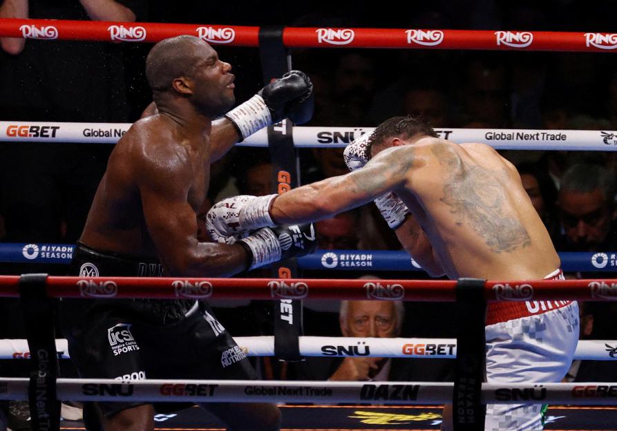 Oleksandr Usyk knocking down Daniel Dubois in a boxing match.