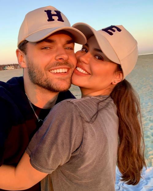 Close-up photo of a couple embracing on a beach.