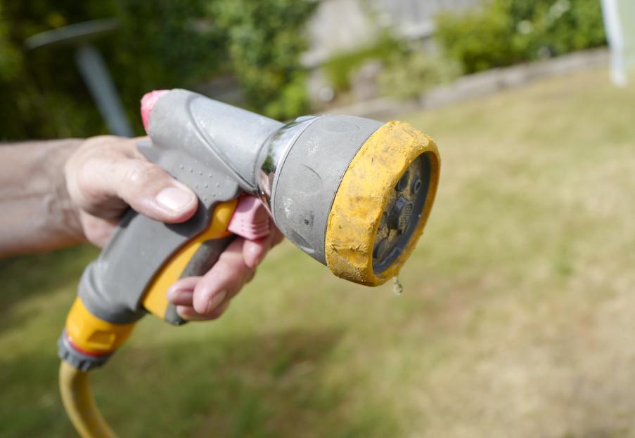 Person turning off a hose during a hosepipe ban.
