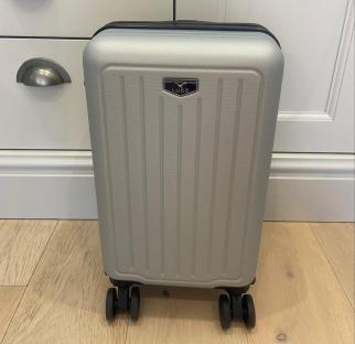 Silver Lugg suitcase on a wooden floor.
