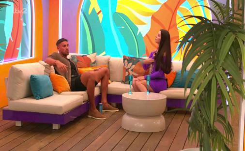 A man and woman arguing on a patio sofa.
