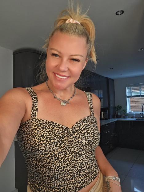 Woman in leopard print top smiling at camera.