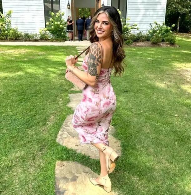 Woman in floral dress walking away from a white chapel.
